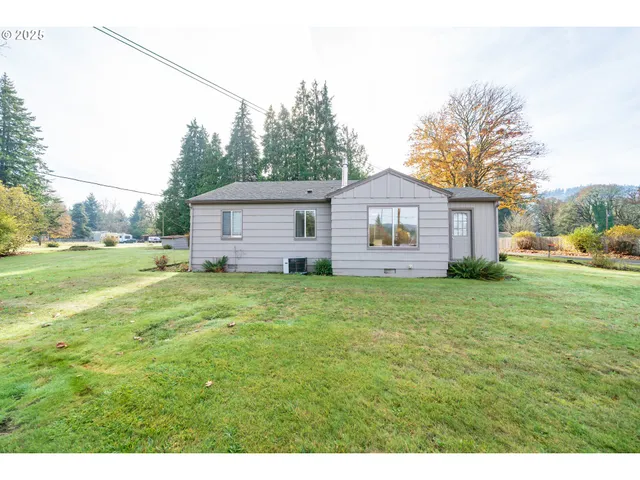 a view of a house with a big yard and large trees