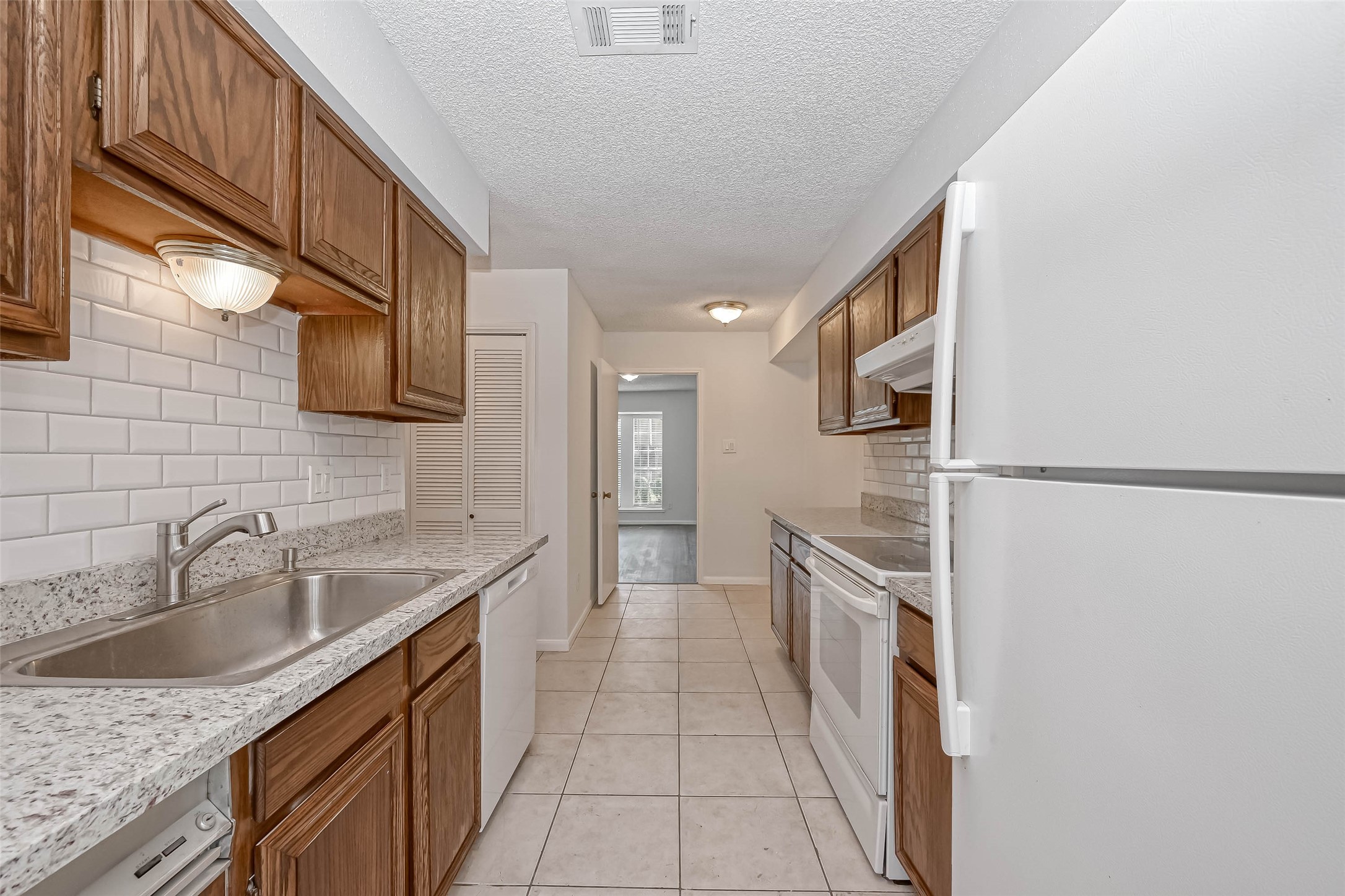 14179 Misty Meadow Lane Houston, TX 77079 - Photo 19 of 41 a kitchen with granite countertop a sink stove and refrigerator