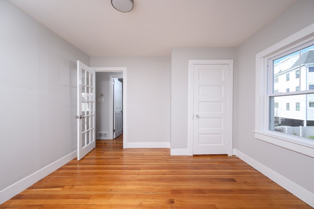 6 Atherton Road, Unit 2 Hull, MA 02045 - Photo 12 of 24 a view of an empty room with wooden floor and window