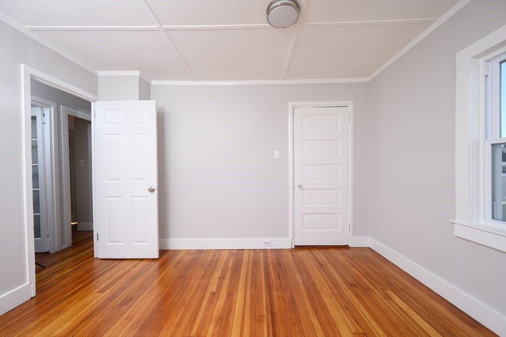 6 Atherton Road, Unit 2 Hull, MA 02045 - Photo 14 of 24 an empty room with wooden floor and windows