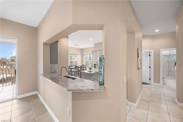 a kitchen with a refrigerator a stove a sink a dining table and chairs