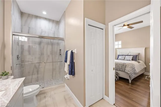 a bathroom with a granite countertop sink a toilet and shower