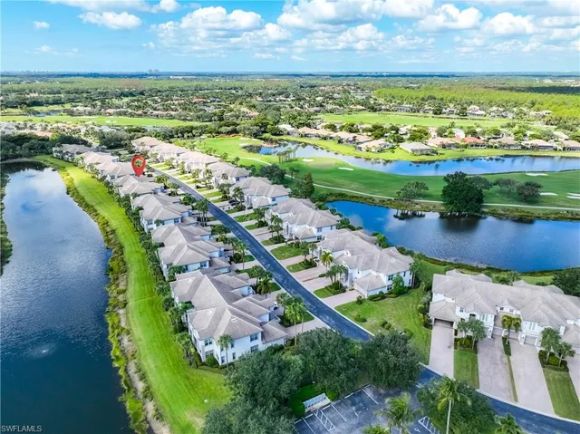 an aerial view of ocean and residential houses with outdoor space