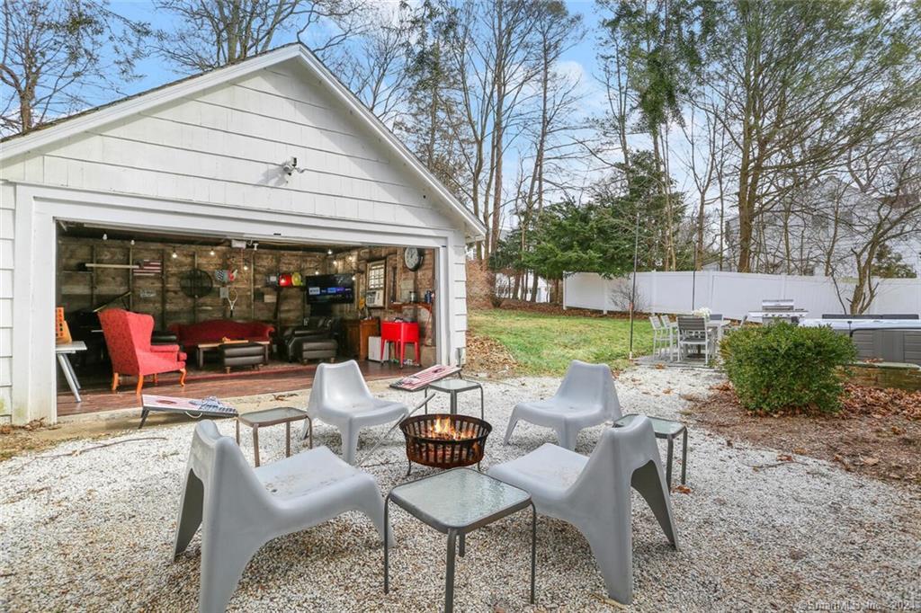61 Hillandale Road Westport, CT 06880 - Photo 29 of 40 a view of a patio with a dining table and chairs under an umbrella