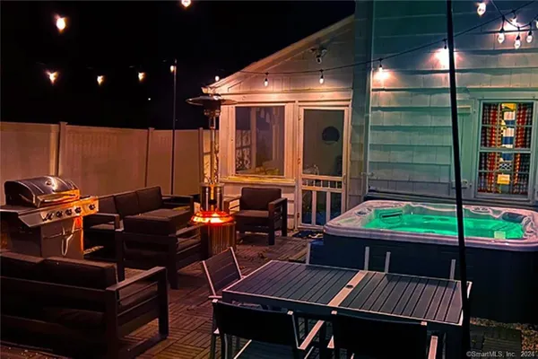 a roof deck with table and chairs with plants
