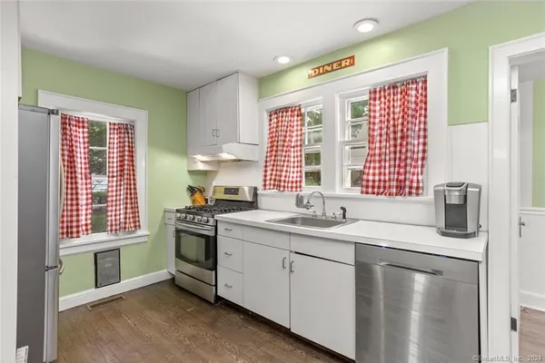 a kitchen with stainless steel appliances granite countertop a sink a stove and a refrigerator