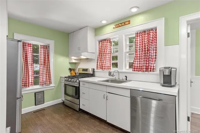 a kitchen with stainless steel appliances granite countertop a sink a stove and a refrigerator