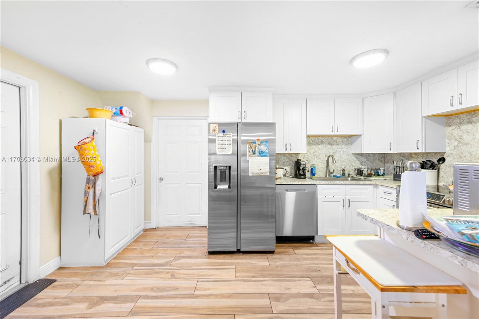 5737 Greene Street Hollywood, FL 33021 - Photo 9 of 19 a kitchen with a refrigerator and white cabinets
