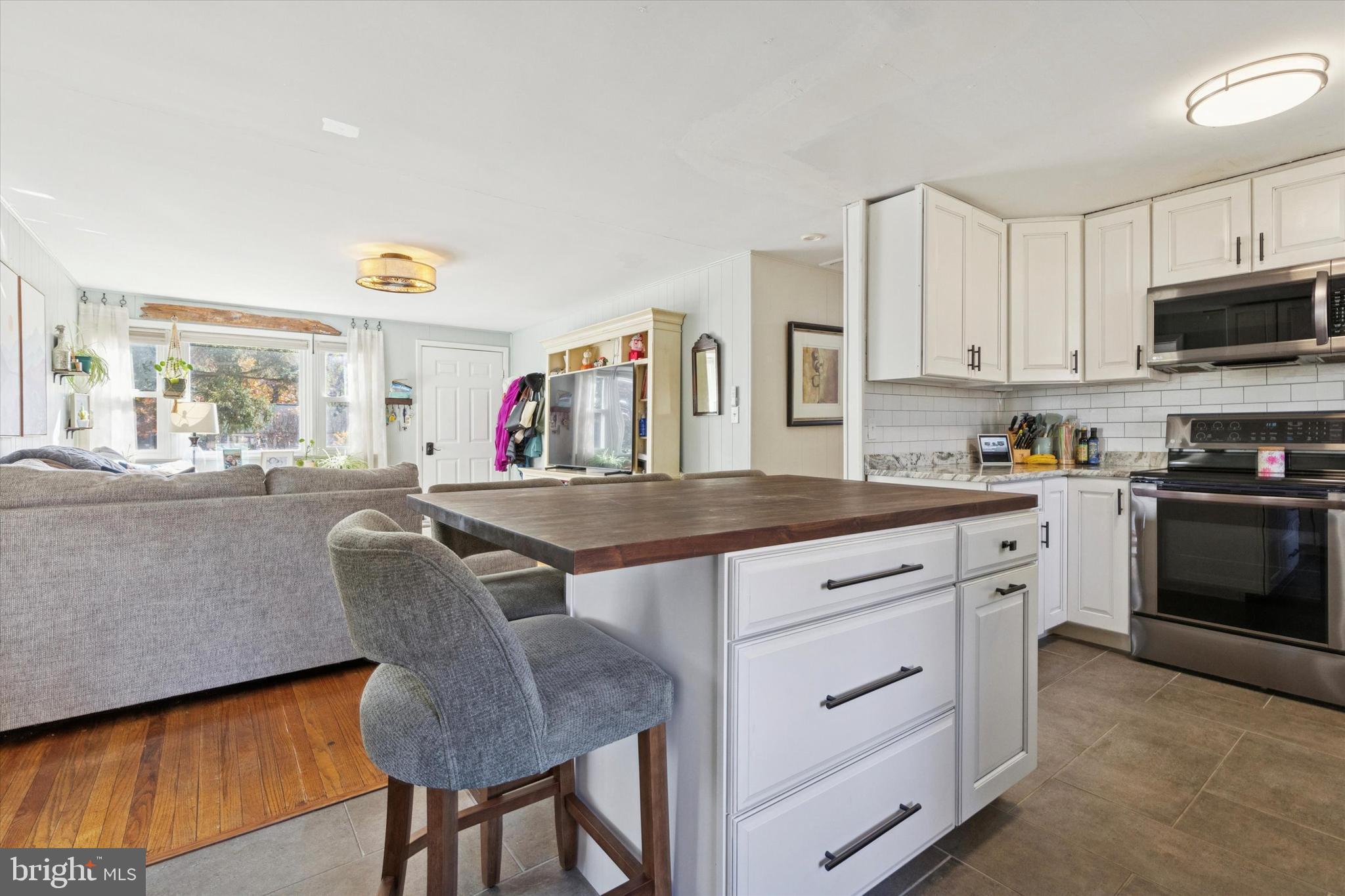 5 Mary Jane Street Spring Mount, PA 19473 - Photo 8 of 25 a kitchen with stainless steel appliances granite countertop a kitchen island a stove a sink a dining table and chairs with wooden floor