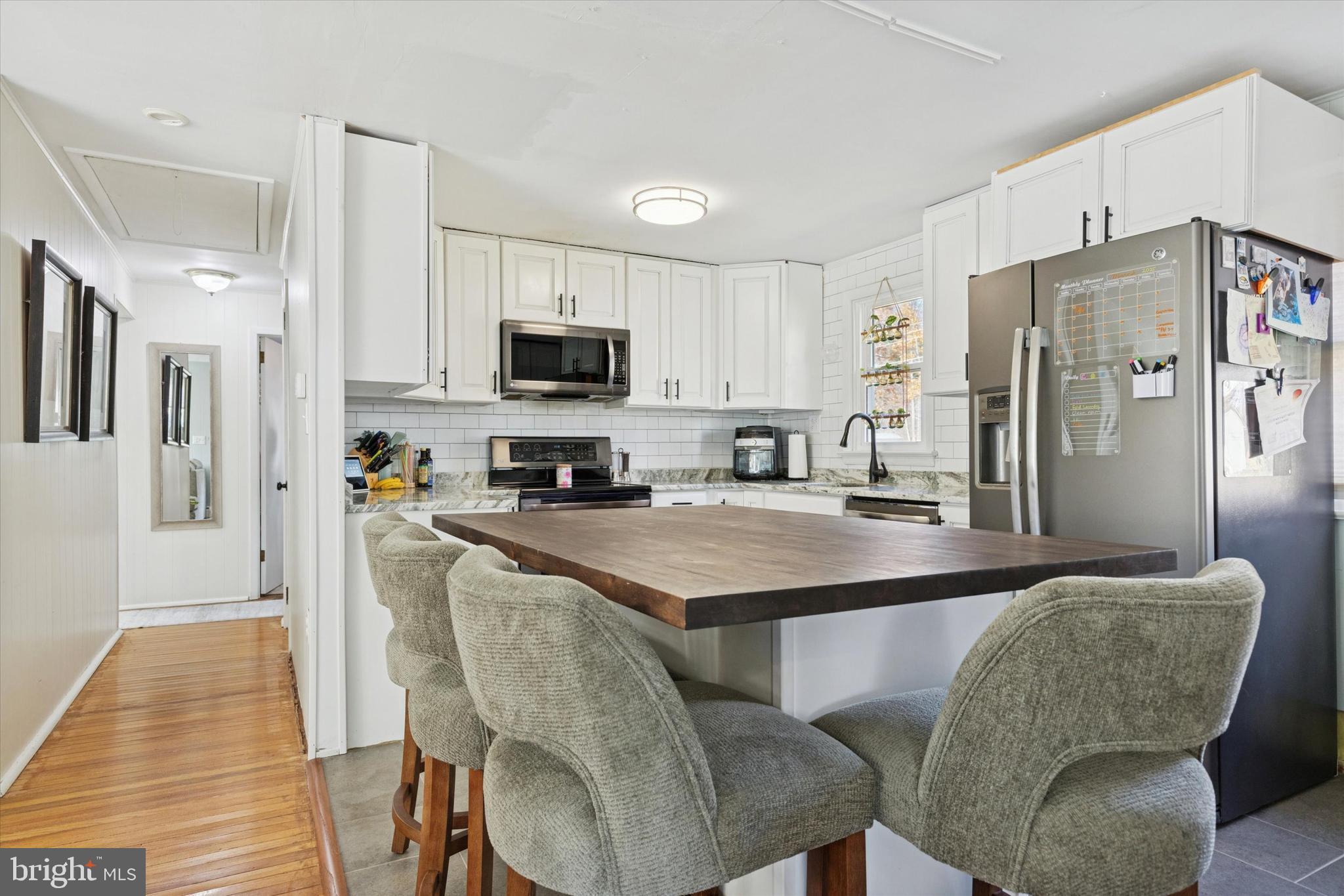 5 Mary Jane Street Spring Mount, PA 19473 - Photo 9 of 25 a kitchen with stainless steel appliances granite countertop a refrigerator a stove a sink a dining table and chairs with wooden floor