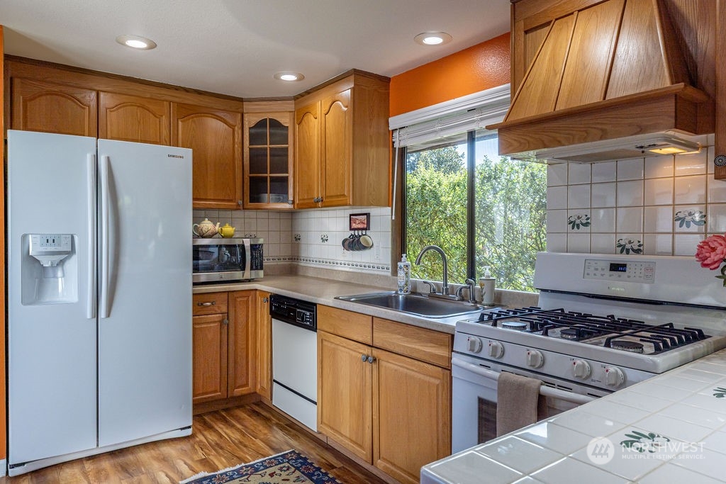 22422 4th Avenue Southeast Bothell, WA 98021 - Photo 24 of 39 a kitchen with stainless steel appliances granite countertop a refrigerator a sink a stove and white cabinets