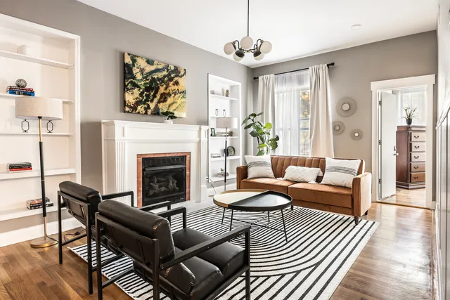 a living room with furniture a chandelier and a fireplace