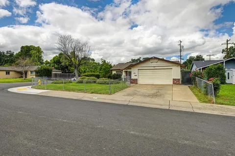 a view of a house with a yard and fence
