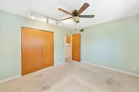 a view of a big room with a ceiling fan and a large window