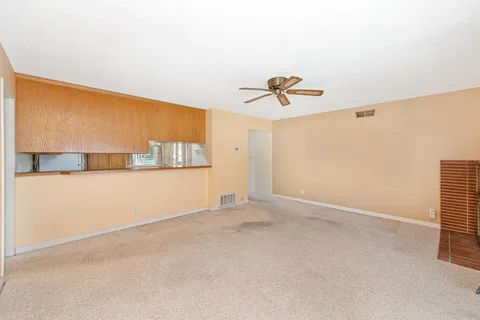 en empty room with a ceiling fan and window