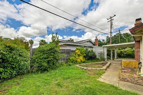 a view of a house with backyard and sitting area
