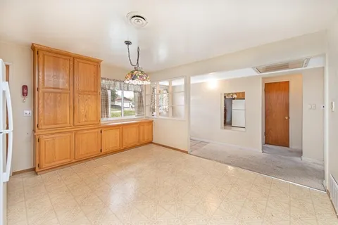 a view of a kitchen with refrigerator and cabinet