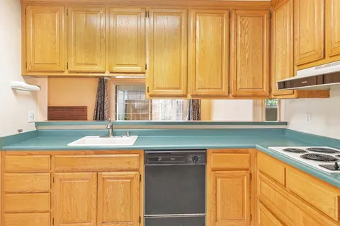 a kitchen with granite countertop cabinets and white appliances