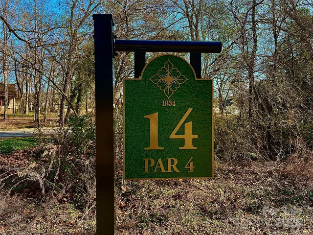 a sign board with a tree in the background