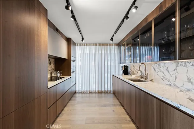 a kitchen with stainless steel appliances granite countertop a sink a stove and a wooden floors