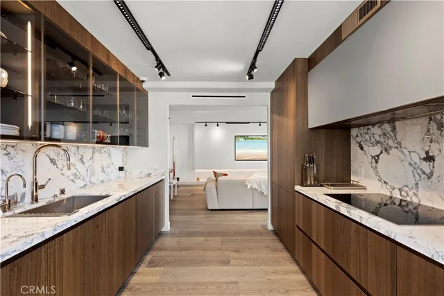 a large kitchen with stainless steel appliances kitchen island granite countertop a sink and dishwasher a stove top oven with wooden floor