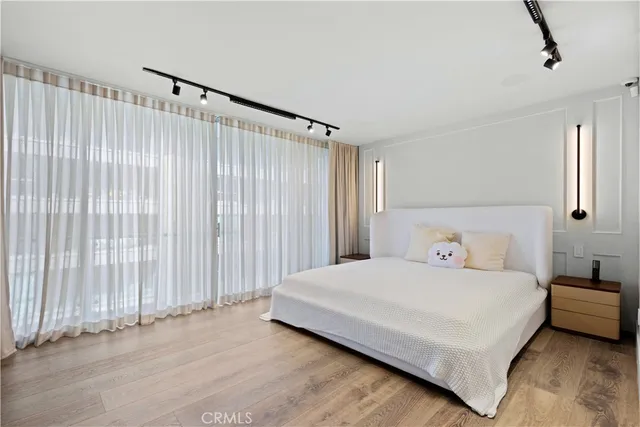 a bedroom with a bed lamp and a large window