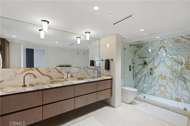 a spacious bathroom with a granite countertop sink a toilet a mirror and shower