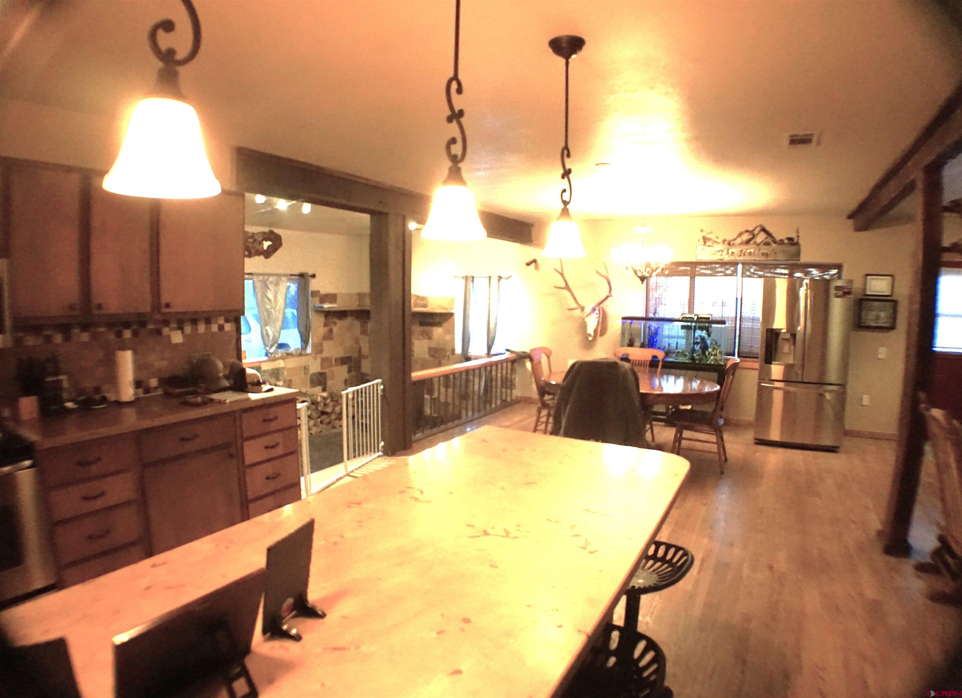 175 County Road Egnar, CO 81325 - Photo 15 of 35 a view of a kitchen with kitchen island stainless steel appliances refrigerator stove dining table and chairs