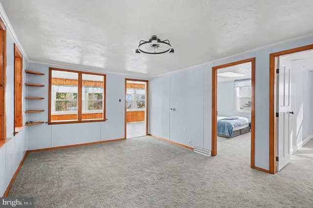 an empty room with windows and closet