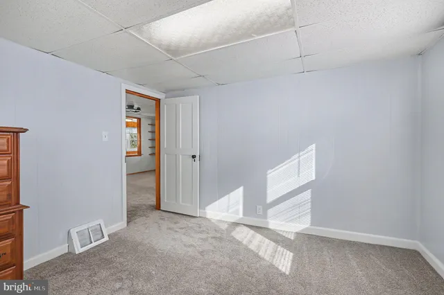 an empty room with windows closet and fireplace