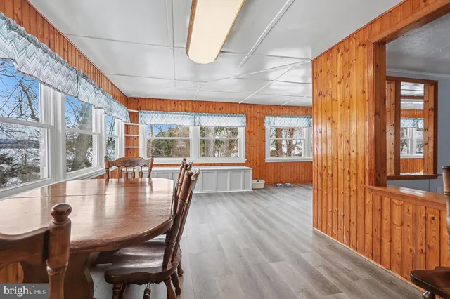 a view of a hallway with wooden floor and windows