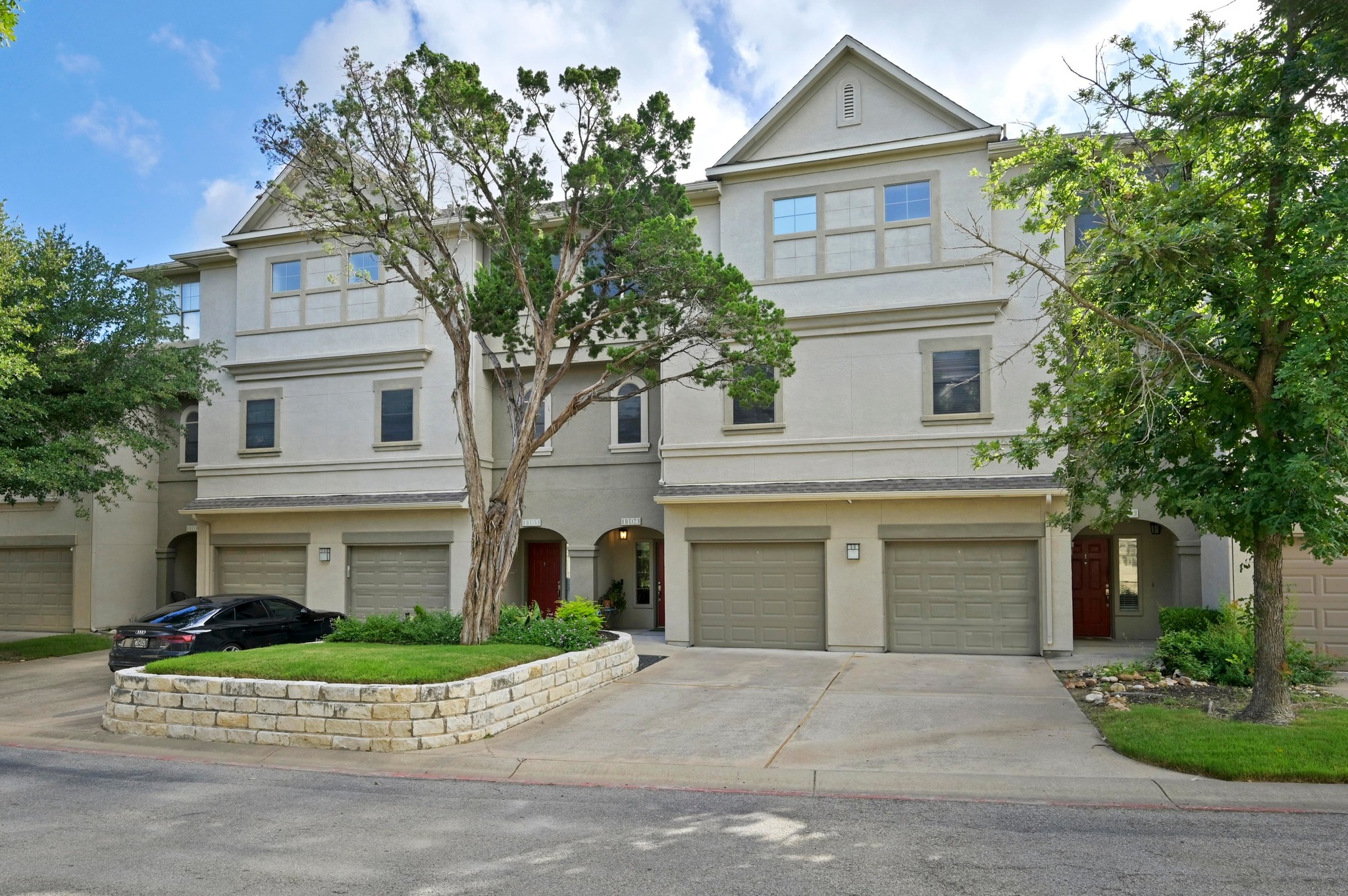 11203 Ranch Road 2222, Unit 1104 Austin, TX 78732 - Photo 20 of 23 View of front of property with stucco siding, a garage, and driveway