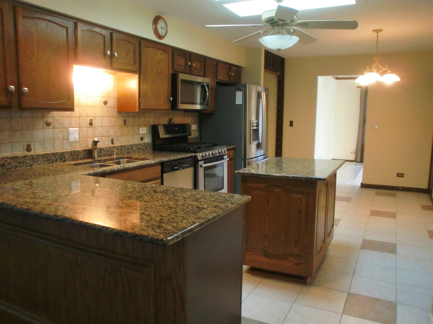 701 Ridge Court Schaumburg, IL 60193 - Photo 7 of 24 a kitchen with kitchen island granite countertop a sink counter top space cabinets and stainless steel appliances