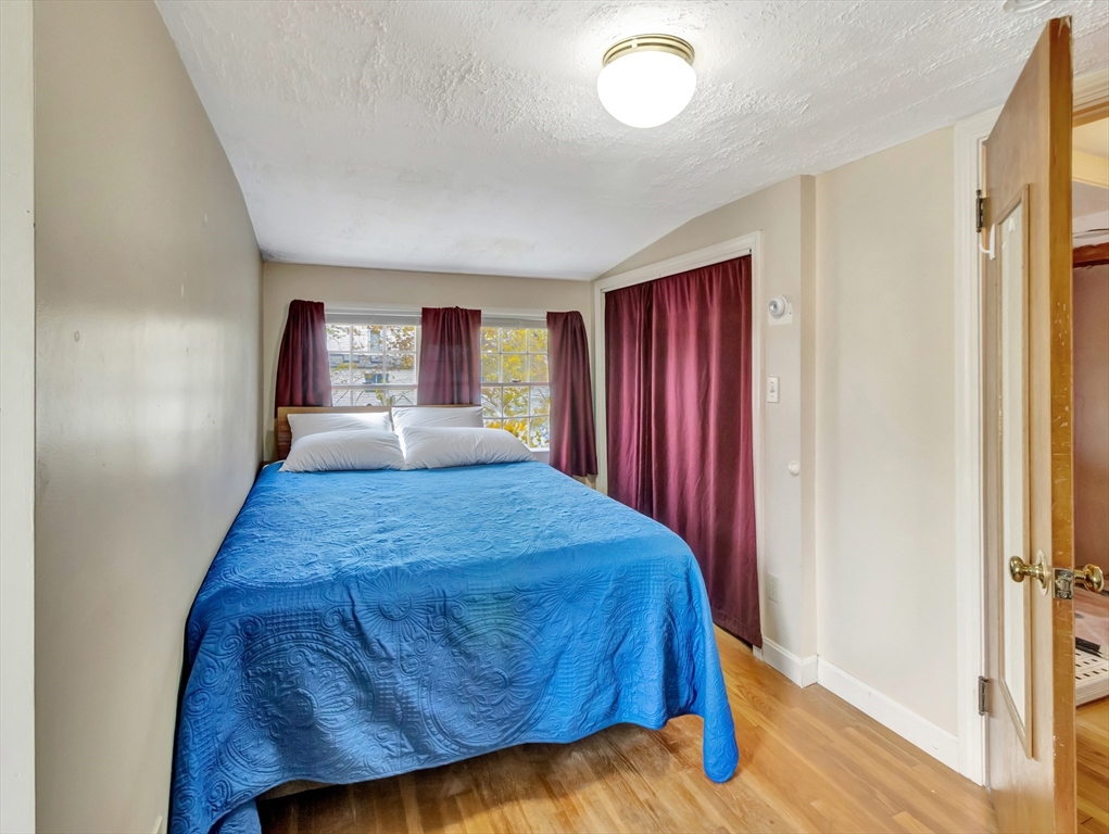 5 G Street Hull, MA 02045 - Photo 32 of 41 a bedroom with a bed and wooden floor