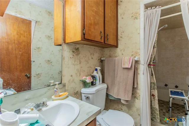 a bathroom with a sink toilet and shower