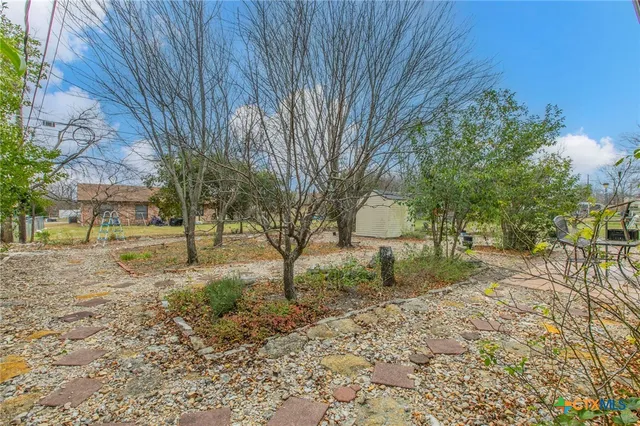 a view of a house with a yard and tree s