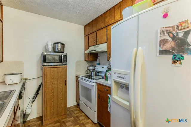 a kitchen with stainless steel appliances a stove refrigerator and a microwave