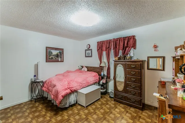 a bedroom with a bed and a painting on the wall