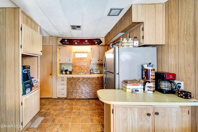 a kitchen with stainless steel appliances granite countertop a sink a refrigerator and a stove