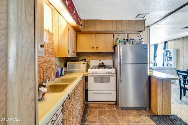 a kitchen with a refrigerator a stove a sink dishwasher and cabinets