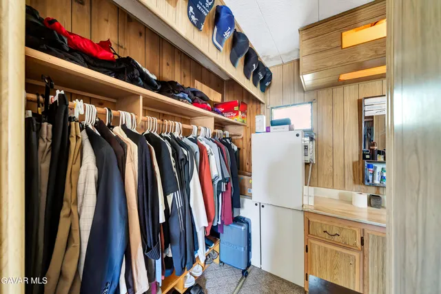 a view of walk in closet with clothes and shoes