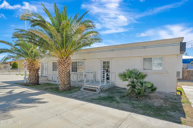 a front view of a house with a tree