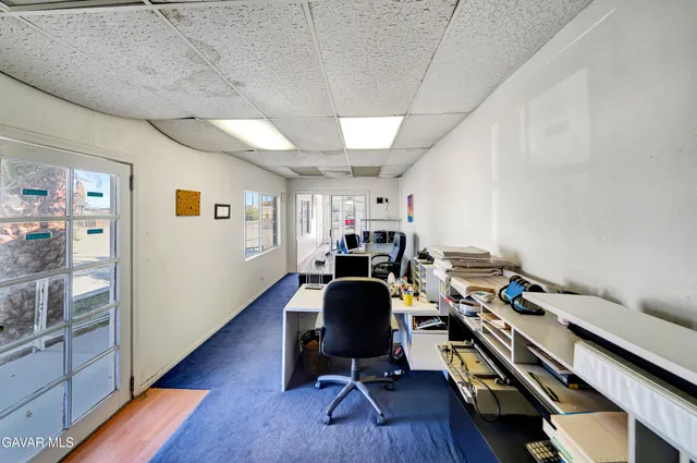 a view of a workspace with furniture and wooden floor
