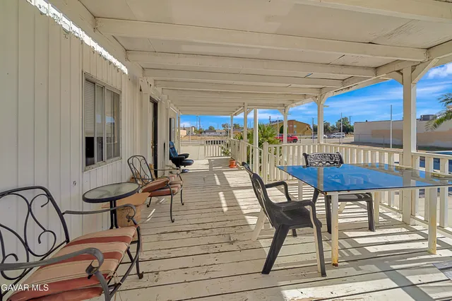 a view of a patio with table and chairs with wooden floor and fence