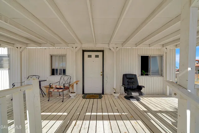 a view of a bedroom with a bed and wooden floor