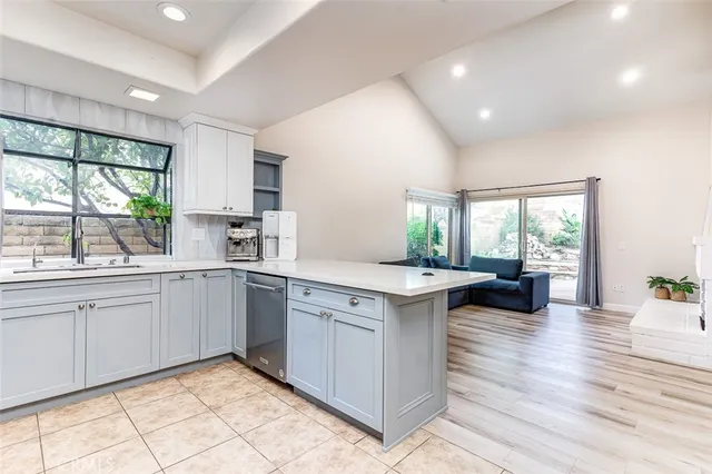 a kitchen with granite countertop white cabinets white appliances sink and a window