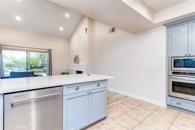 a kitchen with stainless steel appliances kitchen island granite countertop a refrigerator and cabinets