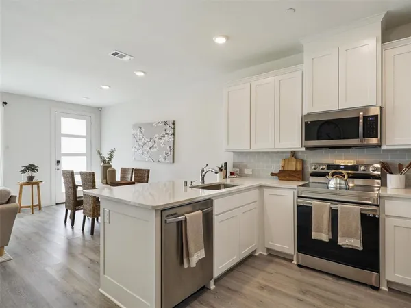 a kitchen with stainless steel appliances granite countertop a sink stove and microwave