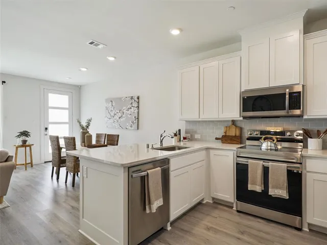 a kitchen with stainless steel appliances granite countertop a sink stove and microwave