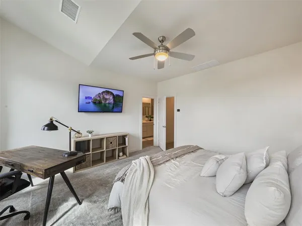 a bedroom with a bed a dresser and a chandelier